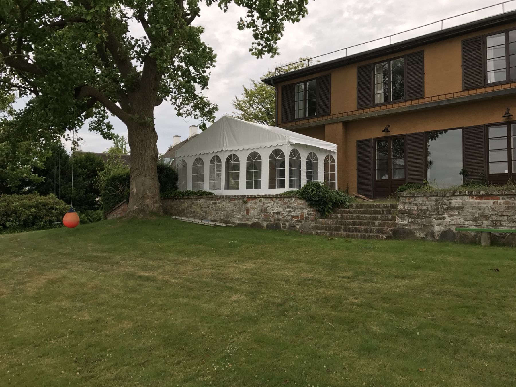Festtelt på terrassen ved en villa med stor have