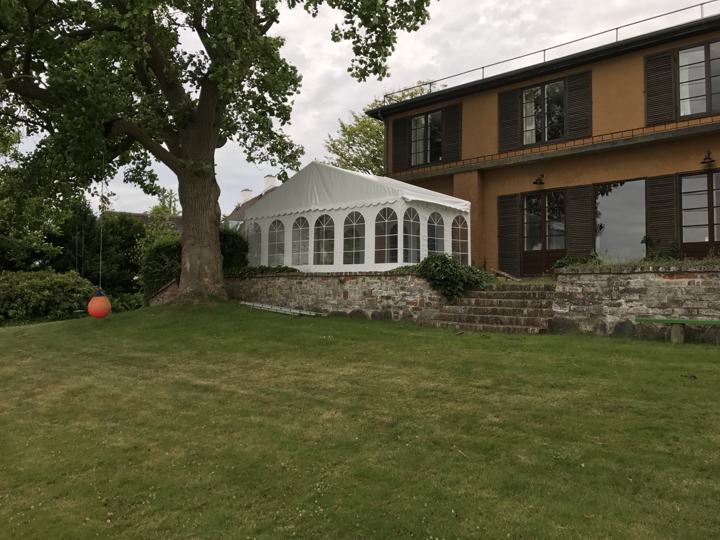 Festtelt på terrassen ved en villa med stor have