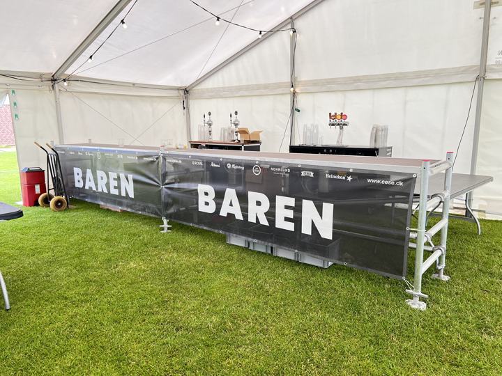 Stilladsbar med fadølsanlæg og lyskæder i et festtelt